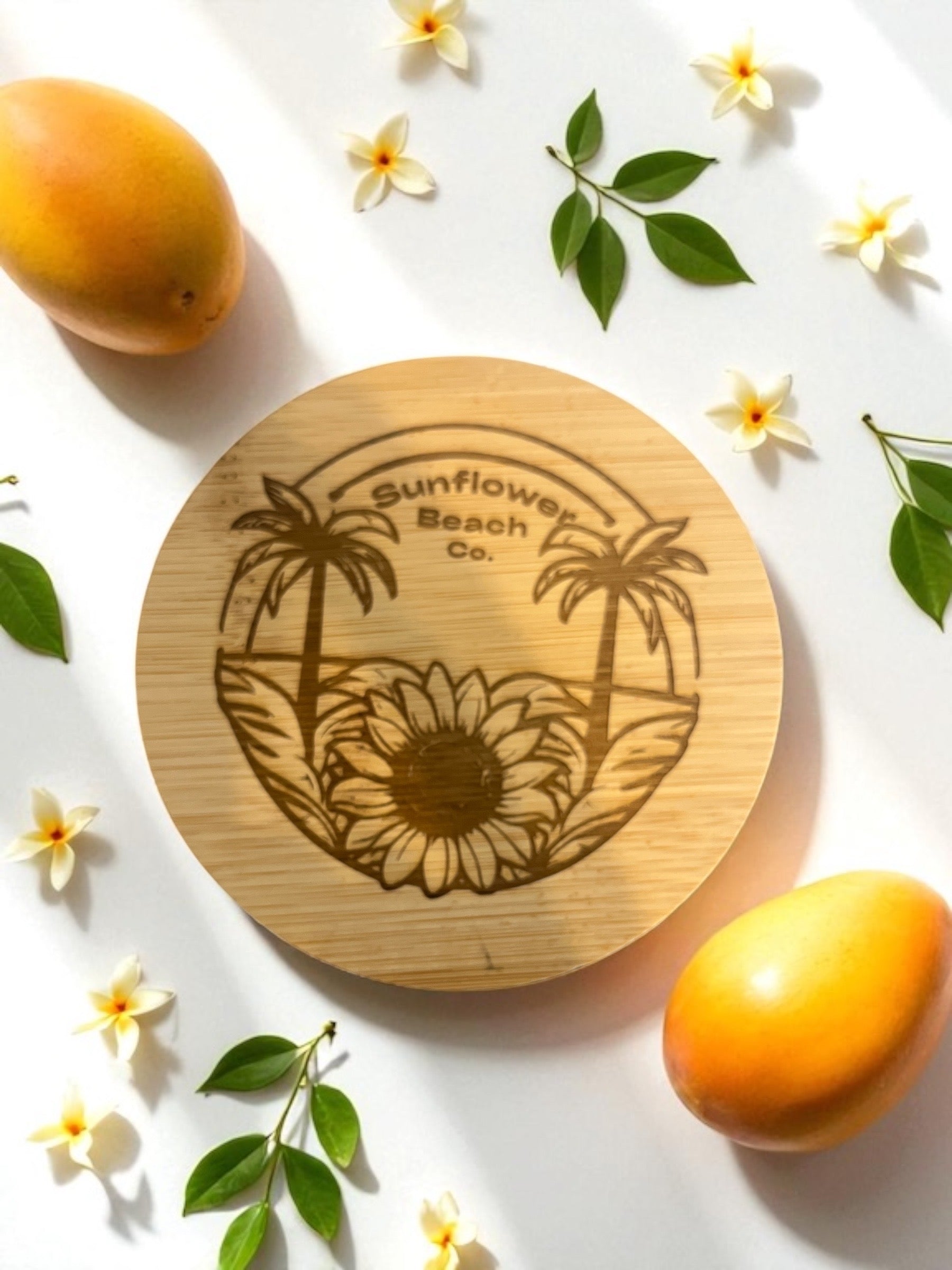 Showcasing the embossed bamboo lid with gardenias and mangos in the backgorund