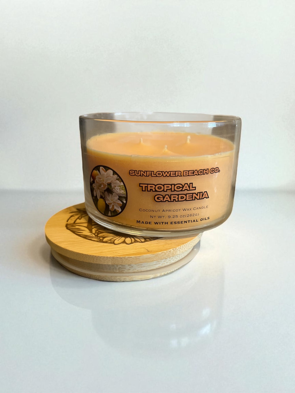 Lid sitting underneath the tropical gardenia three wick candle