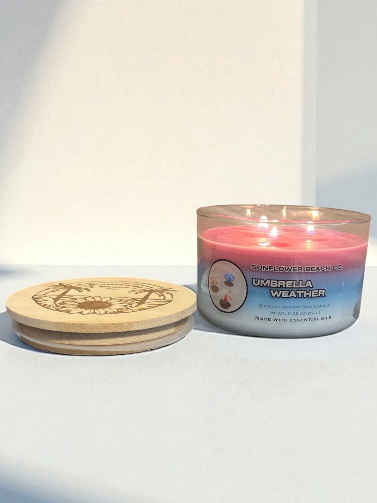Three Wick Sunscreen scented Candle next to Bamboo Embossed Lid