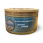 Sunflower Beach Co. candle labeled 'Snow Birds' with a wooden lid on a white background